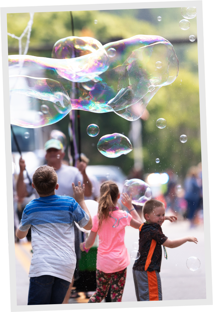 Group of children playing with giant bubbles.