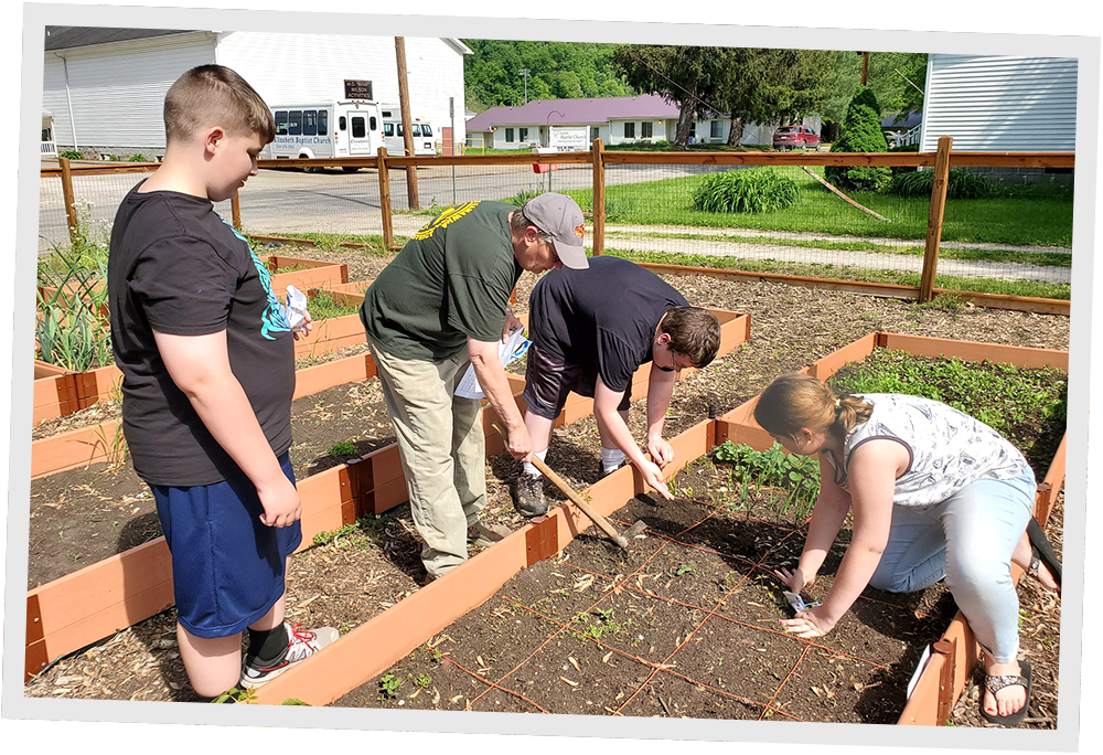 Children and volunteers working in a Wirt County community garden